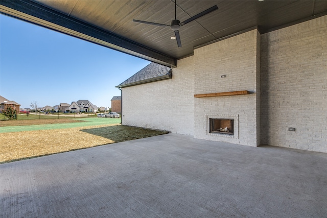 view of patio featuring an outdoor brick fireplace and ceiling fan