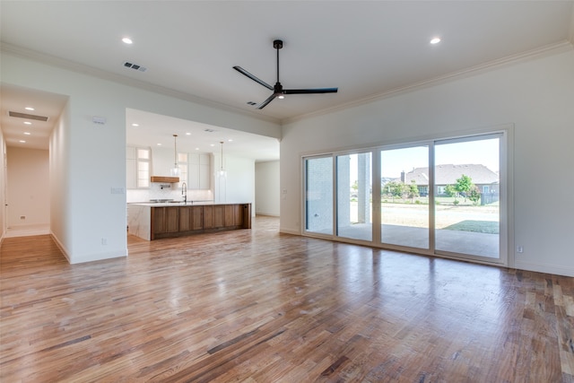 unfurnished living room with ceiling fan, light hardwood / wood-style flooring, and crown molding