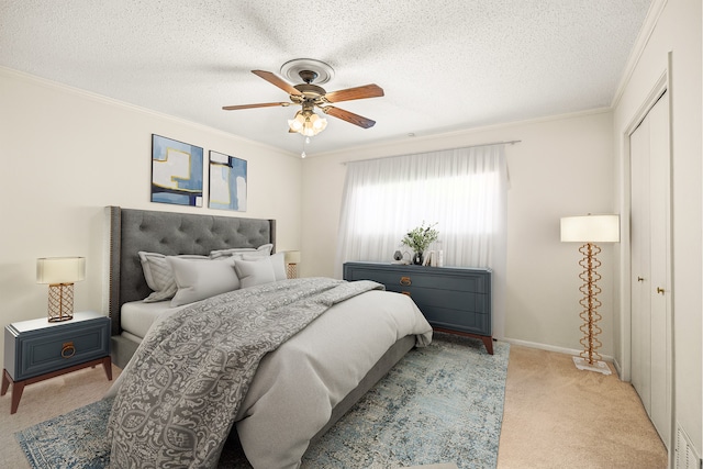 carpeted bedroom featuring a closet, ceiling fan, ornamental molding, and a textured ceiling