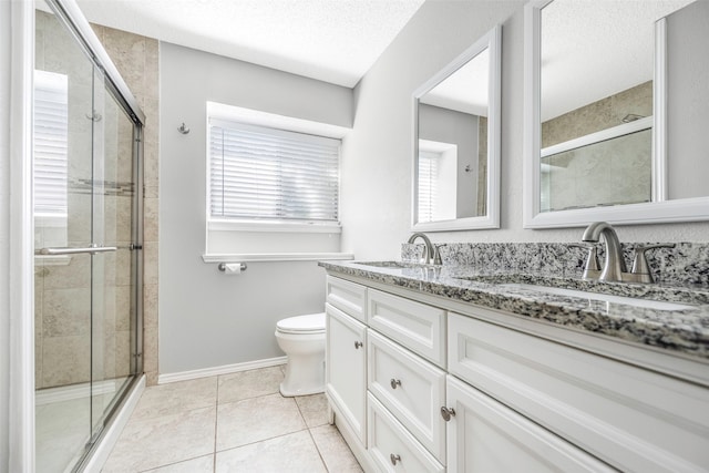 bathroom featuring vanity, tile patterned flooring, toilet, walk in shower, and a textured ceiling