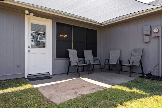 doorway to property featuring a patio and a lawn