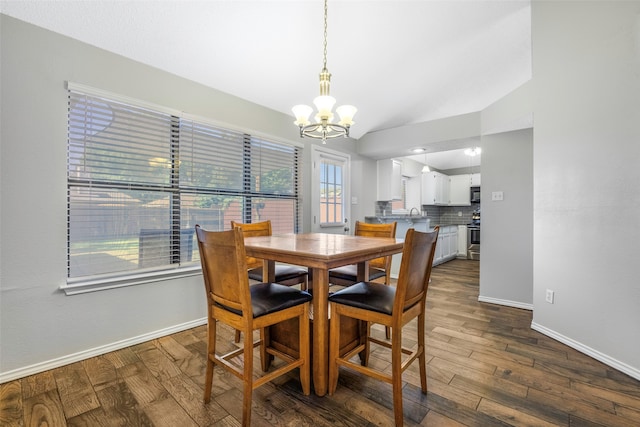 dining room with a notable chandelier, lofted ceiling, and dark wood-type flooring