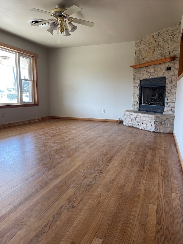 unfurnished living room featuring ceiling fan, hardwood / wood-style floors, and a fireplace