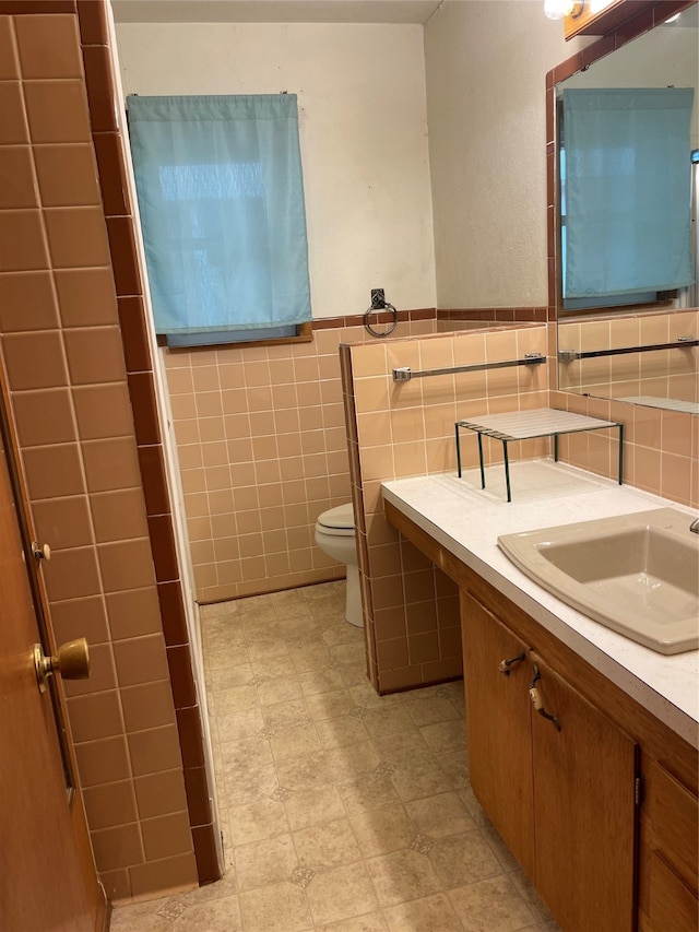 bathroom with tile walls, backsplash, toilet, and vanity