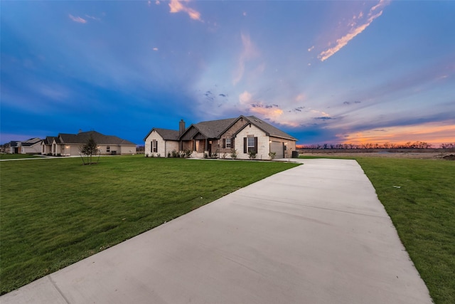 view of front of house featuring a garage and a lawn