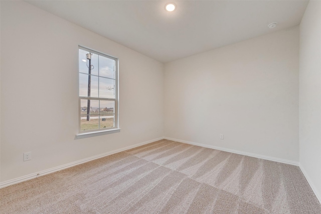 spare room featuring light carpet