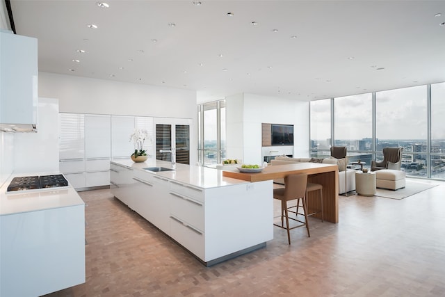 kitchen featuring a spacious island, a wealth of natural light, gas stovetop, and white cabinets