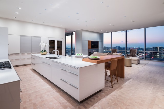 kitchen featuring a large island, white cabinetry, and sink