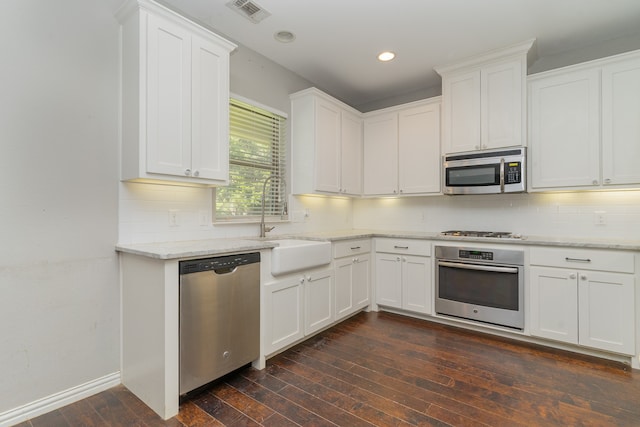 kitchen featuring dark wood-type flooring, white cabinetry, light stone counters, and stainless steel appliances