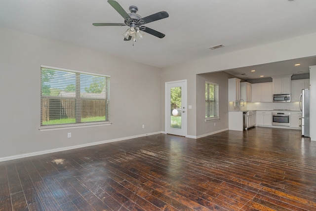 unfurnished living room featuring dark hardwood / wood-style floors, sink, and ceiling fan