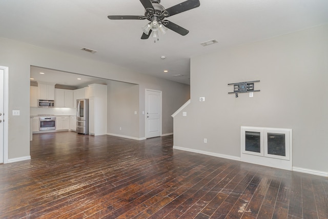 unfurnished living room with dark wood-type flooring and ceiling fan