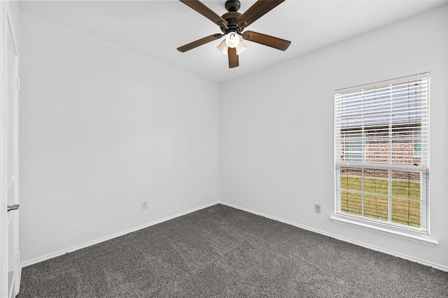 empty room with dark colored carpet and ceiling fan