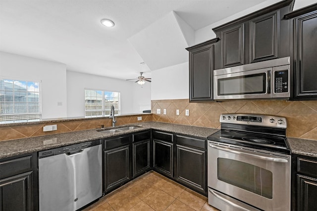 kitchen with backsplash, light tile patterned floors, appliances with stainless steel finishes, sink, and ceiling fan