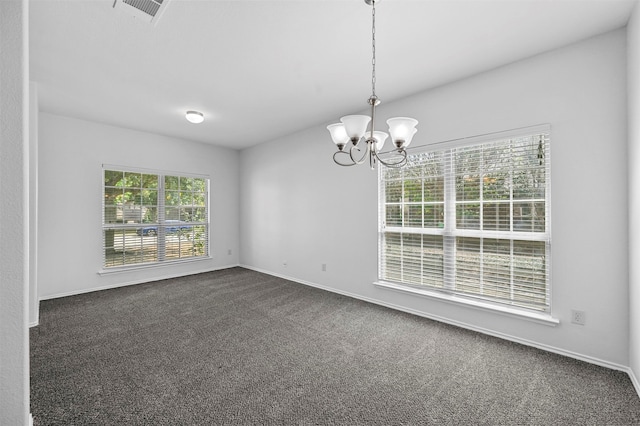 unfurnished room with an inviting chandelier and dark colored carpet