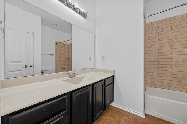 full bathroom featuring tiled shower / bath, vanity, toilet, and tile patterned flooring