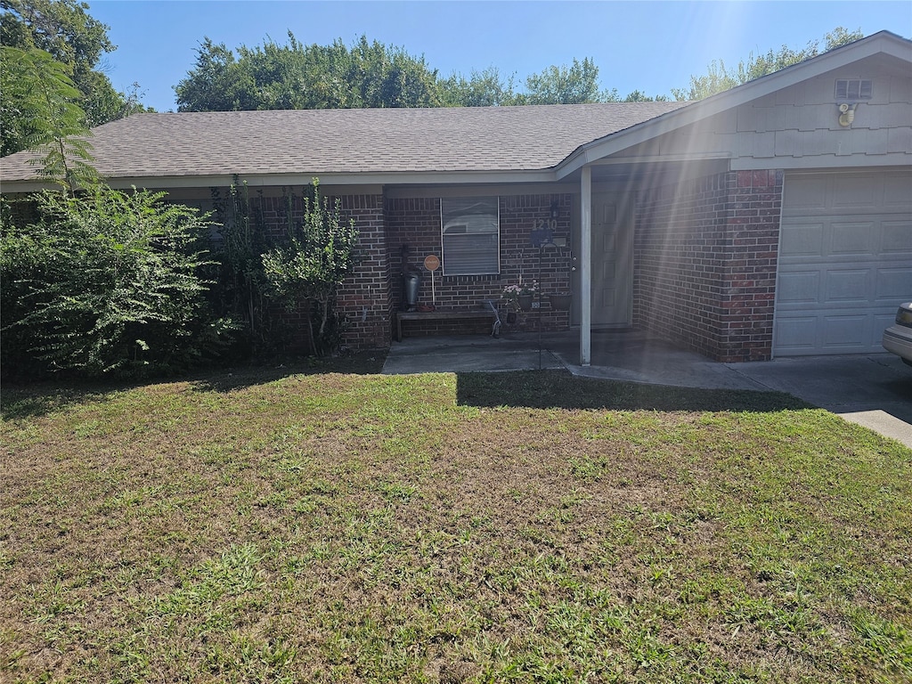 view of front of property with a front yard and a garage