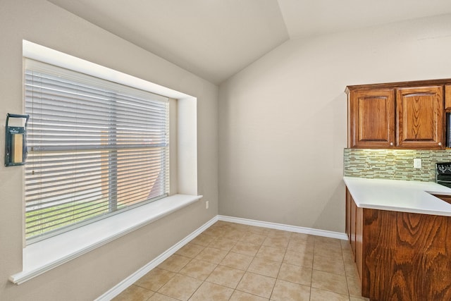 kitchen with vaulted ceiling, backsplash, and light tile patterned flooring