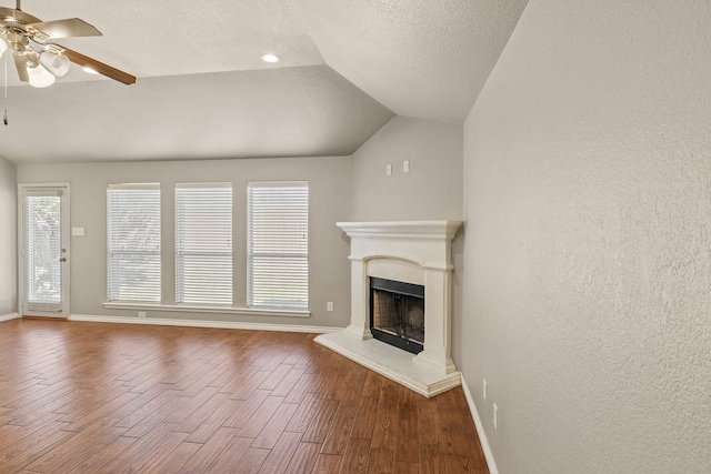 unfurnished living room with a textured ceiling, wood-type flooring, ceiling fan, and lofted ceiling