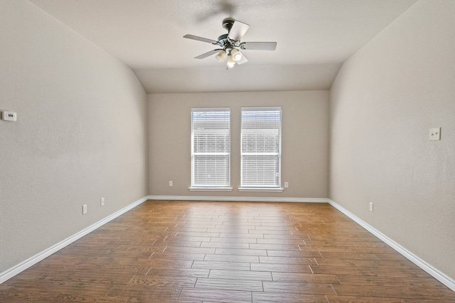 empty room featuring vaulted ceiling, hardwood / wood-style flooring, and ceiling fan