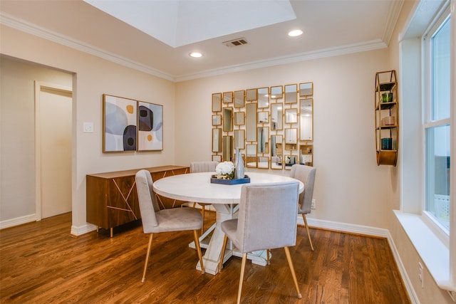 dining space featuring dark hardwood / wood-style floors, ornamental molding, and a healthy amount of sunlight