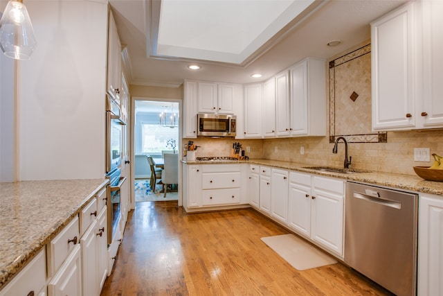 kitchen featuring light stone countertops, light hardwood / wood-style floors, stainless steel appliances, sink, and white cabinetry