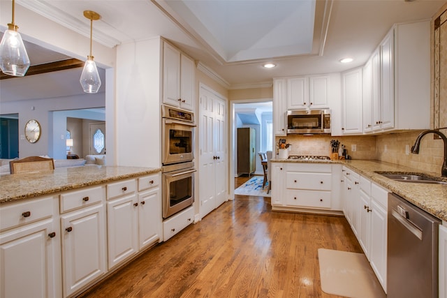 kitchen featuring white cabinetry, decorative light fixtures, and stainless steel appliances