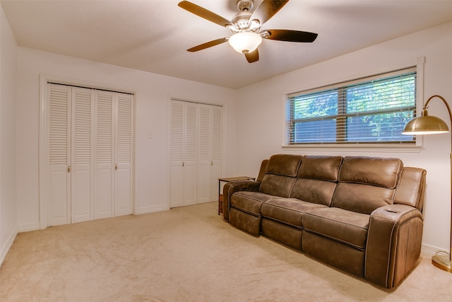 carpeted living room with ceiling fan