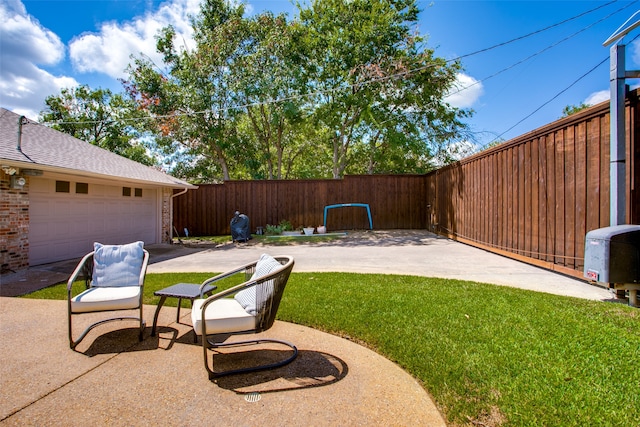 view of yard featuring a garage and a patio area