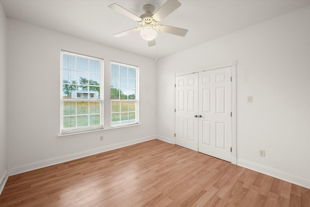 unfurnished bedroom with light hardwood / wood-style flooring, ceiling fan, and a closet