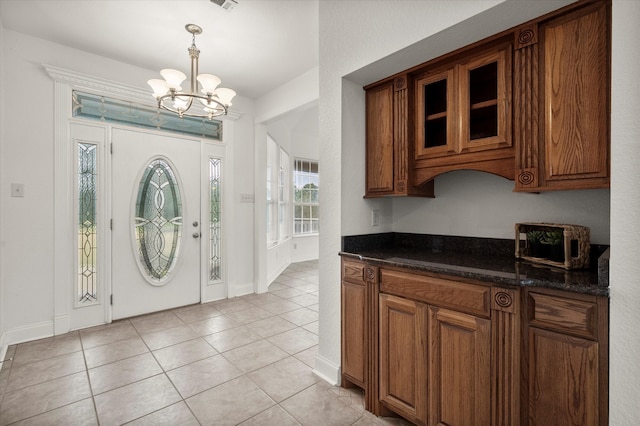 foyer with a chandelier and light tile patterned floors