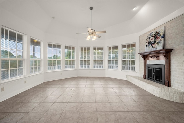 interior space featuring lofted ceiling, ceiling fan, light tile patterned floors, and a fireplace