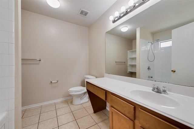 bathroom featuring tile patterned floors, toilet, a tile shower, and vanity