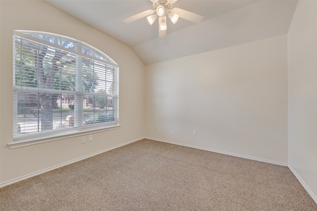 carpeted spare room with vaulted ceiling, plenty of natural light, and ceiling fan