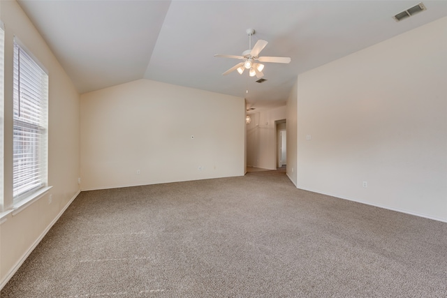 spare room with vaulted ceiling, ceiling fan, and carpet flooring