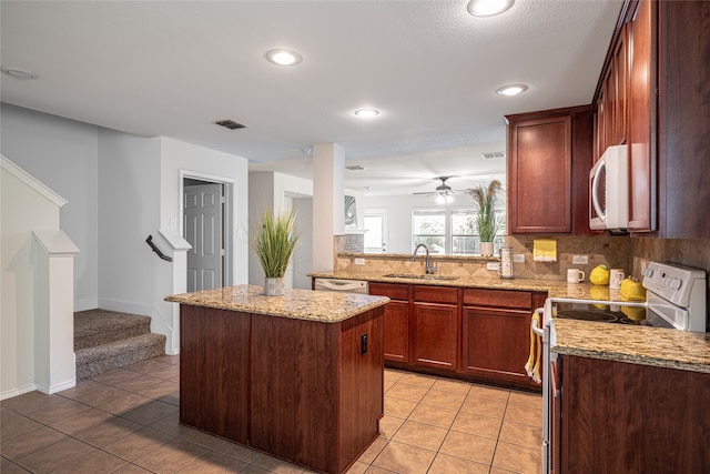 kitchen featuring sink, light tile patterned floors, tasteful backsplash, white appliances, and a kitchen island