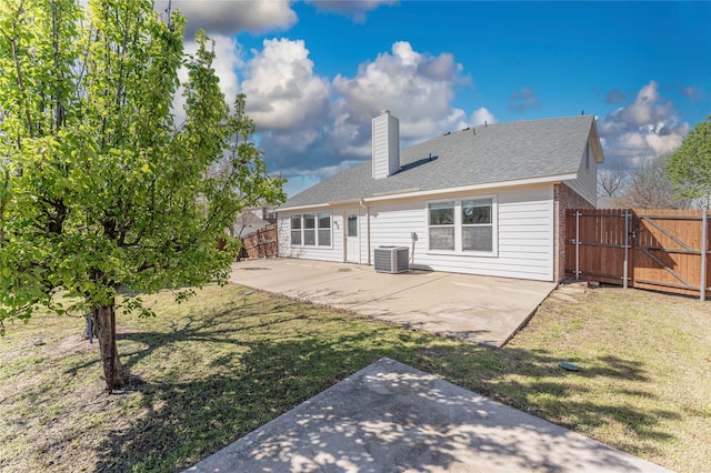 back of property with central AC unit, a patio area, and a yard