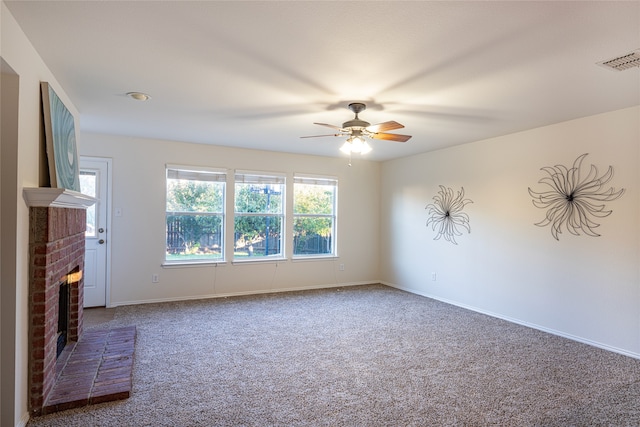 unfurnished living room with carpet, ceiling fan, and a brick fireplace