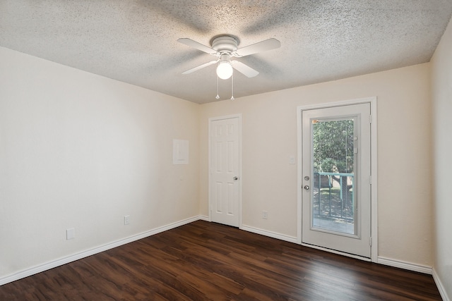 empty room with dark hardwood / wood-style flooring, ceiling fan, and a textured ceiling