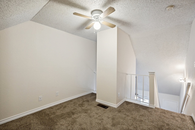 bonus room with a textured ceiling, lofted ceiling, ceiling fan, and carpet floors