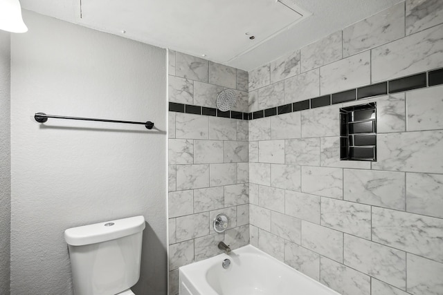 bathroom featuring toilet and tiled shower / bath combo