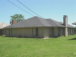 rear view of house featuring a yard