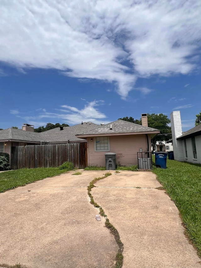 rear view of property featuring a lawn