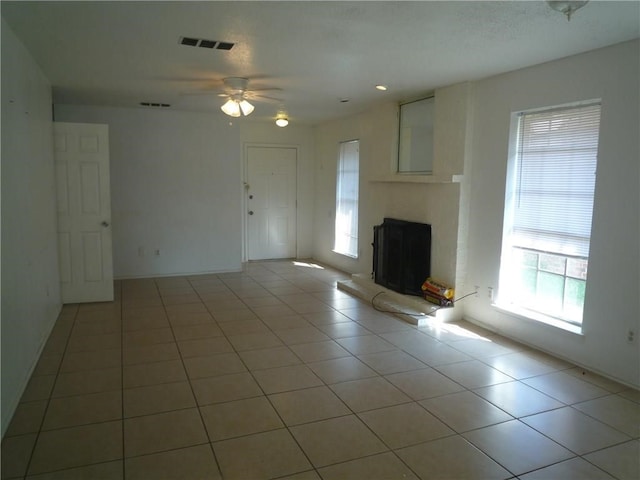 unfurnished living room with ceiling fan, light tile patterned floors, and a healthy amount of sunlight