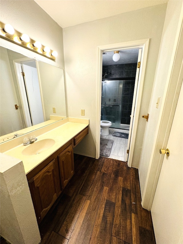 bathroom featuring an enclosed shower, toilet, hardwood / wood-style flooring, and vanity