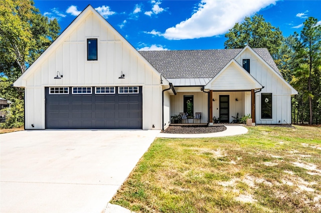 modern farmhouse featuring a front yard, a garage, and covered porch