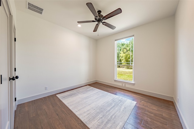 empty room with dark hardwood / wood-style flooring and ceiling fan