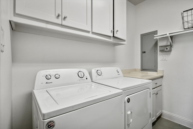 clothes washing area featuring separate washer and dryer, electric panel, and cabinets