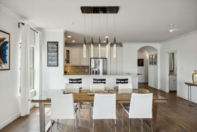 dining room with dark wood-type flooring and crown molding