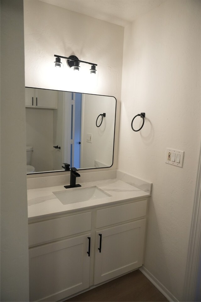 bathroom featuring vanity and toilet