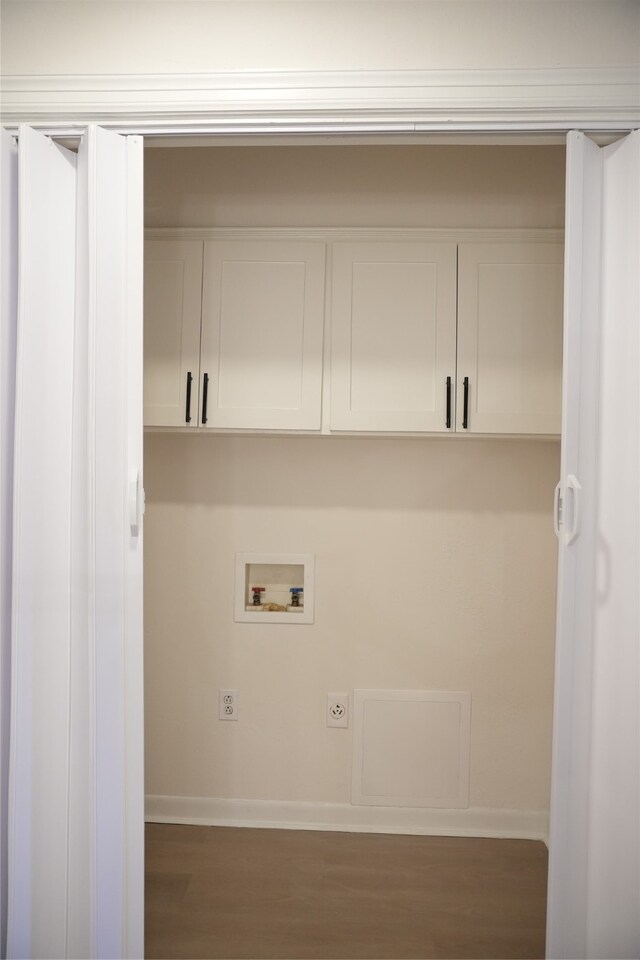 laundry area featuring dark wood-type flooring, hookup for a washing machine, and cabinets